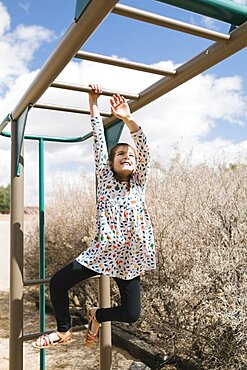 Girl (2-3) on monkey bars