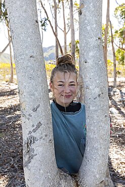 South Africa, Stanford, Teenage girl (16-17) standing next to gum trees at Phillipskop Mountain Reserve