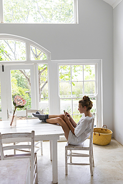 teenage girl using her smart phone in light filled room