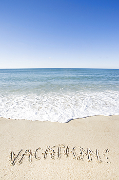 Vacation message written in beach sand