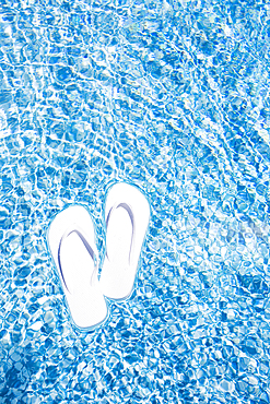 Flip Flops floating on swimming pool water surface