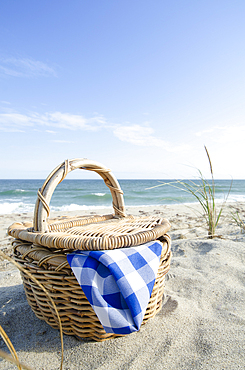 Picnic basket on sandy beach