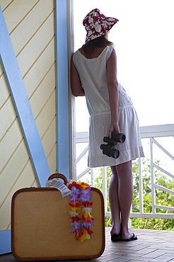 Rear view of woman with suitcase at Caribbean vacation villa