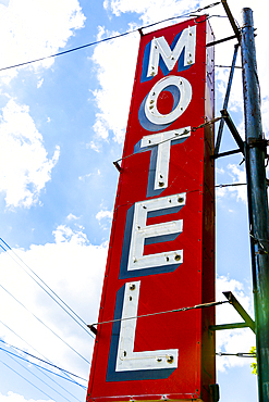 Low angle view of red and white Motel sign against sky