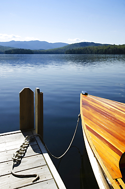 Antique wood boat tied to dock on Lake Placid, Saranac Lake, New York, USA