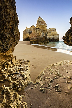 A sea cave frames the ocean and the imposing cliffs at dawn, Praia da Rocha, Portimao, Faro district, Algarve, Portugal, Europe