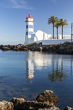 The lighthouse reflected in the blue water under the blue summer sky, Cascais, Estoril Coast, Lisbon, Portugal, Europe