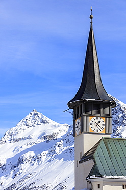 The typical alpine bell tower frames the snowy peaks, Langwies, district of Plessur, Canton of Graubunden, Swiss Alps, Switzerland, Europe