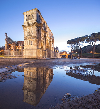 The historical Arch of Constantine reflected in a puddle at dusk, Rome, Lazio, Italy, Europe