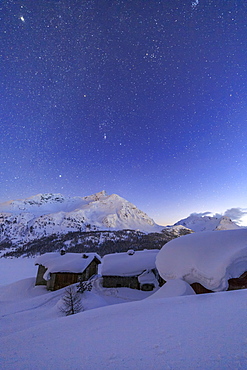 The huts of Spluga covered in thick snow during a clear starry night, Graubunden, Swiss Alps, Switzerland, Europe