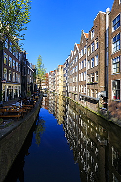 Typical houses reflected in the blue water of a canal, Amsterdam, Holland (The Netherlands), Europe