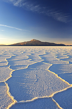 An Andean volcano rises above the Salar de Uyuni, the incredible salt desert, during a summer sunset, Oruro, Bolivia, South America