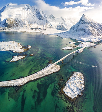 Aerial panoramic view of snowy peak of Volanstinden and Fredvang bridge, Lofoten Islands, Nordland, Norway, Europe