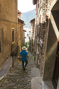 Man walks down old alley, Corenno Plinio, Dervio, Lake Como, Lecco province, Lombardy, Italy, Europe