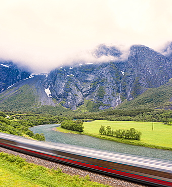 The Rauma Line express train runs beside the river in Romsdalen Valley, Andalsnes, More og Romsdal county, Norway, Scandinavia, Europe