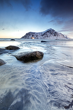 Sunset on the surreal Skagsanden beach surrounded by snow covered mountains, Flakstad, Lofoten Islands, Arctic, Norway, Scandinavia, Europe