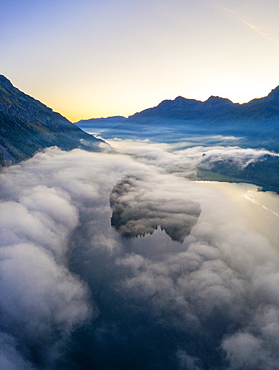 Lake Silvaplana and Sils hidden by the autumnal fog at dawn, aerial view by drone, Engadine, Canton of Graubunden, Switzerland, Europe