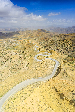 Panoramic view by drone of winding road towards Berhale crossing the dry landscape of Danakil desert, Afar Region, Ethiopia, Africa