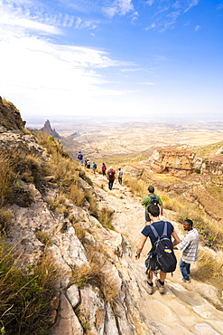 Hikers venture on rock path towards the rock-hewn churches of Gheralta Mountains, Tigray Region, Ethiopia, Africa