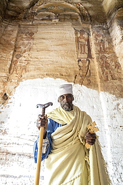 Orthodox priest holding the hand cross and prayer stick in Maryam Korkor church, Gheralta Mountains, Tigray Region, Ethiopia, Africa