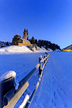 Wood fence in the snow surrounding the church of San Gian, Celerina, St. Moritz, Engadine, canton of Graubunden, Switzerland, Europe