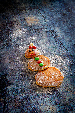 Cute decorated pancakes in shape of snowman on table background made by children for Christmas, Italy, Europe