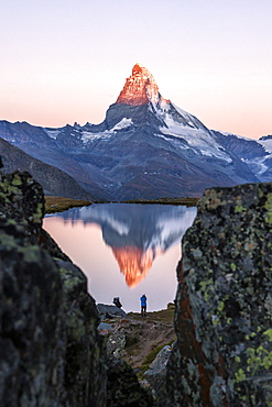 Hikers admire the Matterhorn reflected in the Stellisee at sunrise, Zermatt, Canton of Valais, Pennine Alps, Swiss Alps, Switzerland, Europe