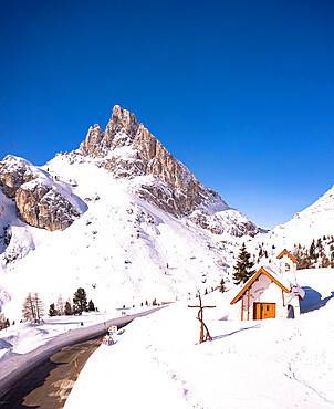 Alpine chapel in the snowy landscape with Sass de Stria peak in the background, Falzarego Pass, Belluno province, Veneto, Italy, Europe