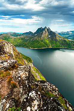 Cloudy sky over the calm water of Mefjord and majestic Breidtinden mountain, Senja island, Troms county, Norway, Scandinavia, Europe