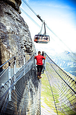 One person looking at the cable car from the Thrill Walk cliff pathway, Murren Birg, Jungfrau Region, Bern canton, Switzerland, Europe