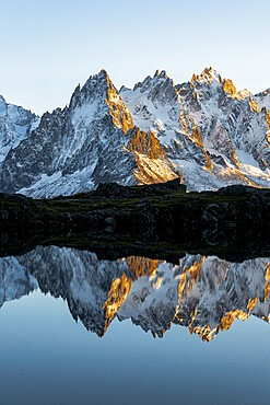 Rocky peaks of Aiguilles de Chamonix reflected in Lacs des Cheserys at sunset, Mont Blanc Massif, Haute Savoie, French Alps, France, Europe