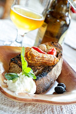 Greek appetizer of stuffed zucchini flowers served with bruschetta and tzatziki sauce in wood bowl, Crete, Greek Islands, Greece, Europe