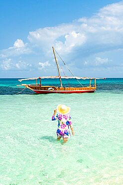 Woman sunbathing in the crystal turquoise sea, Kwale Island, Zanzibar, Tanzania, Africa