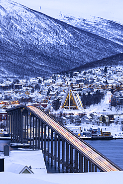 Dusk over the illuminated Bruvegen Bridge and Arctic Cathedral in winter, Tromso, Norway, Scandinavia, Europe