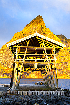 Fishing racks overlooking the cold sea with Olstind mountain peak on background, Sakrisoy, Reine, Lofoten Islands, Nordland, Norway, Scandinavia, Europe