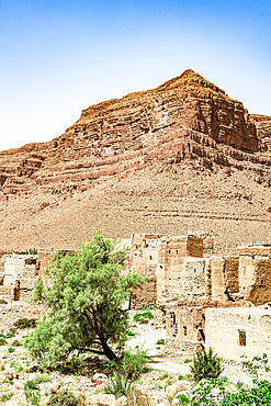 Mudbrick buildings of an ancient village with red canyons in backgrounds, Ziz Valley, Atlas mountains, Morocco, North Africa, Africa