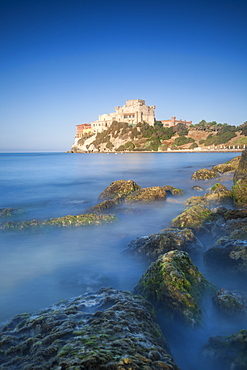 Alongside a picturesque millstone, atop a rocky promontory dominating the sea, rises the Castello di Falconara, Sicily, Italy, Mediterranean, Europe