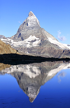 Hiker admiring the Matterhorn reflected in Lake Stellisee, Zermatt, Canton of Valais, Pennine Alps, Swiss Alps, Switzerland, Europe