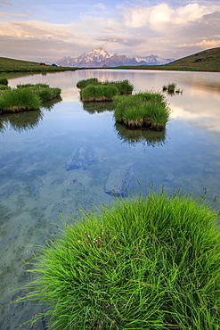 The snowy peaks reflected in the clear water of Lake Campagneda at sunrise, Malenco Valley, Valtellina, Lombardy, Italy, Europe