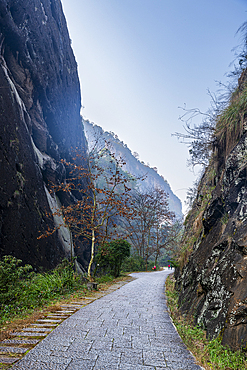 Road leading through huge granite rock walls, Mount Wuyi, UNESCO World Heritage Site, Wuyi Mountains, Fujian, China, Asia