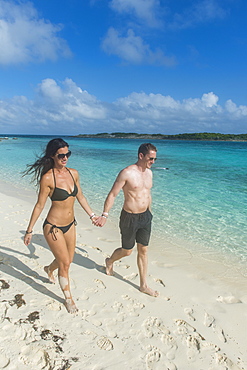 Couple walking on a white sand beach, Exumas, Bahamas, West Indies, Caribbean, Central America