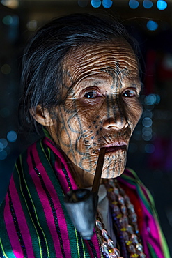 Chin woman with spiderweb tattoo smoking a pipe, Mindat, Chin state, Myanmar (Burma), Asia