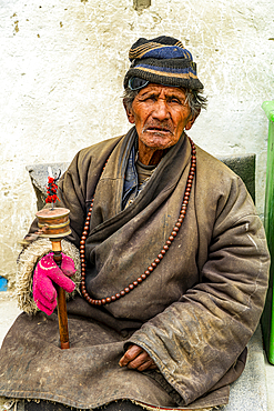 Old man with a prayer wheel in his hand, Kingdom of Mustang, Nepal, Asia