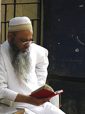 India. Muslim reading outside a mosque, mumbai