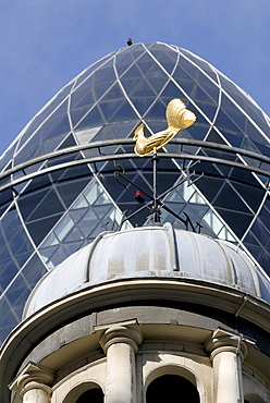 Uk old dome with the tower of the swiss re modern building in the background in the city of london