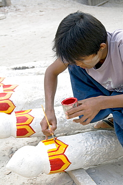 Myanmar (burma) man painting buddha statues at a workshop near mandalay