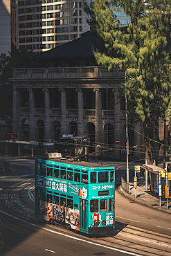 An vertical action shot of a Hong Kong Tram going past the colonial Building Old Supreme Court