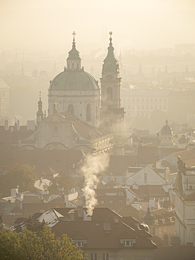 Rooftops and St. Nicholas Church at sunrise from Petrin Hill in autumn, Prague, Czechia (Czech Republic), Europe