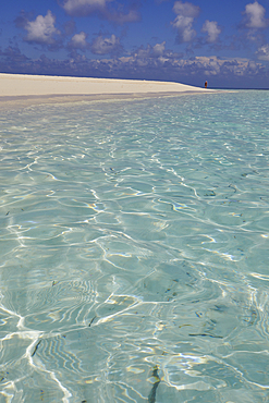 Pristine shallow waters lap against the white coral sand of a tropical beach; Havodda Island, in the far south of the Maldives, Gaafu Dhaalu atoll, Indian Ocean.
