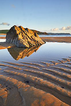 A rock pool and rippled sand, on the beach at low tide, at Bigbury-on-Sea, south coast of Devon, England, United Kingdom, Europe